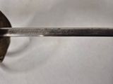 a silver spoon with a handle on a white surface