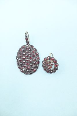 a close up of a pair of earrings on a white surface