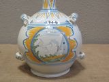 a white vase with a picture on it sitting on a table