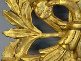 a gold clock with a bird on top of it