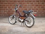 a small motorcycle parked in front of a brick wall