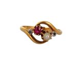 a close up of a gold ring with a pearl and a ruby stone