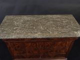 a small marble top chest of drawers on a black background