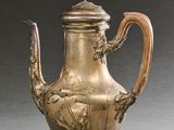 une théière ancienne en argent surmontée d'un oiseau