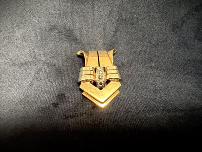 a gold plated metal object on a black surface