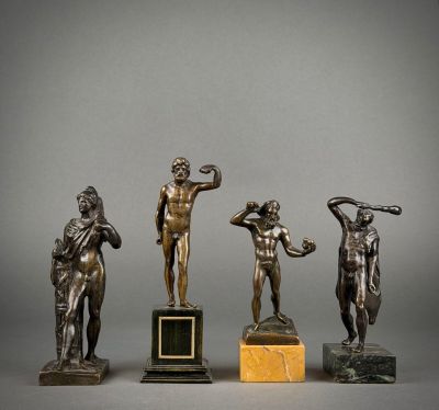 three bronze statues of a man holding a tennis racquet and a woman holding a tennis racquet