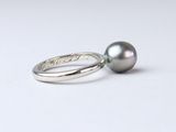 a close up of a ring with a black pearl on it
