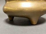 a gold pot sitting on a table with a black background