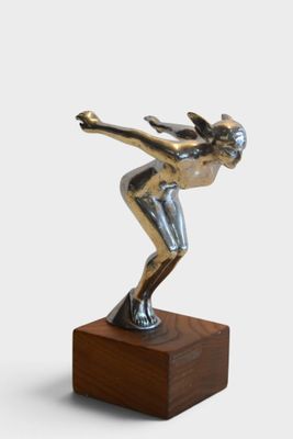 statue of a female figure on a wooden base with a white background