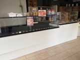 a counter with a glass display case in the middle of it