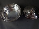 a silver plate with a lid on a black table