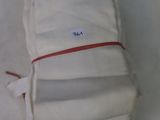 a stack of folded towels on a plate with a red ribbon