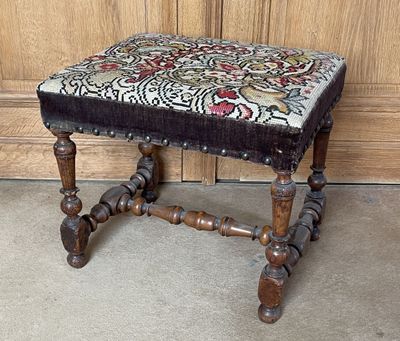 un petit tabouret en bois orné d'un motif floral