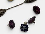 an image of a collection of jewelry including a spoon, broochet, and other items