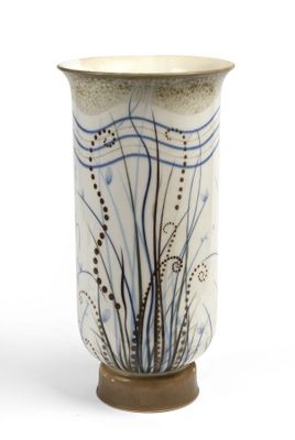 un vase blanc orné de motifs bleus et marron