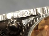 someone is holding a silver ring with a citrine stone in it