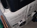 a television sitting on top of a refrigerator in a room