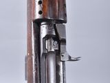 a close up of a rifle with a wooden handle on a gray background