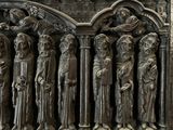 a statue of a group of people standing in front of a building