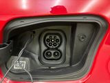 a red car that has a black power cord in it