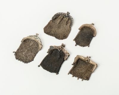 five small purses are lined up on a white surface