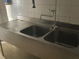 two sinks in the kitchen with a faucet and faucet on the wall