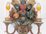 a wall sconce with a bunch of flowers and candles on it