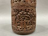 a wooden vase with carvings on it sitting on a table