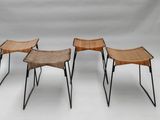 trois chaises aux pieds noirs et à l'assise en osier, sur fond blanc