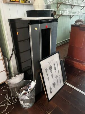 une photo d'une cuisine avec un réfrigérateur et une photo d'ustensiles posés par terre