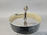 a silver and black bowl with a spoon in it