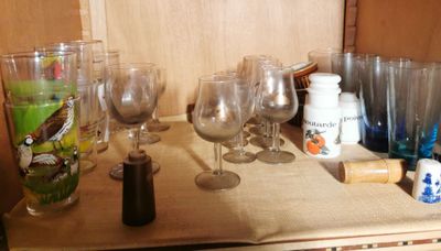 many wine glasses sitting on a shelf in the kitchen