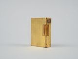un gros plan d'un étui à cigarettes doré posé sur une surface blanche