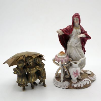 deux figurines représentant une femme et un chien avec un parapluie