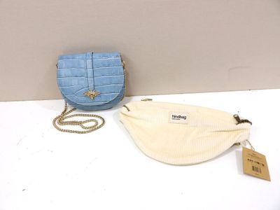 a blue purse and a white bag on a table