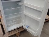 an open refrigerator sitting on a pallet in a warehouse