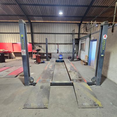 a picture of a garage with two lifts in it