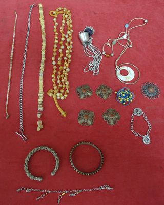 many different types of jewelry on a red surface