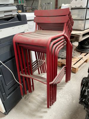 une pile de chaises rouges posées sur un tas de cartons