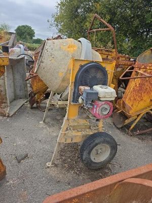 une bétonnière posée au milieu d'un tas de ferraille
