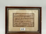 une vieille photo encadrée représentant une citation, accrochée au mur