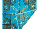 a close up of a blue and brown scarf with flowers on it