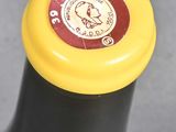 a black bottle with a yellow top and a yellow cap