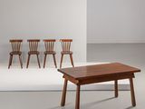 trois chaises et une table dans une pièce aux murs blancs