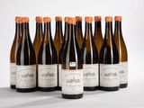 six bouteilles de vin sont alignées sur une table