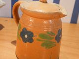 a small pitcher with a lid sitting on a table