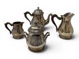 three pieces of silver tea and coffee set on a white surface