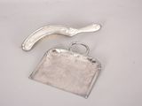 a silver purse and a banana on a white table