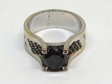 bague en argent sertie d'une pierre noire sur un fond blanc