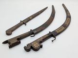 three antique chinese swords with wooden handles on a white surface